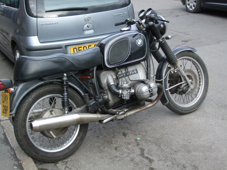 a motorcycle is parked next to the parked car