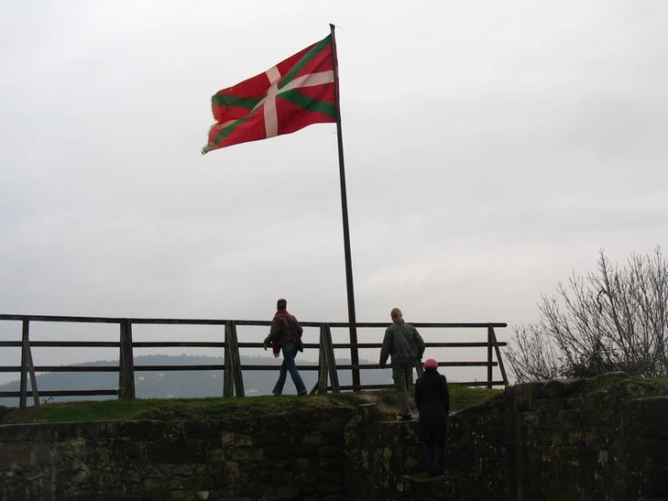 the flag is flying in front of the group of people