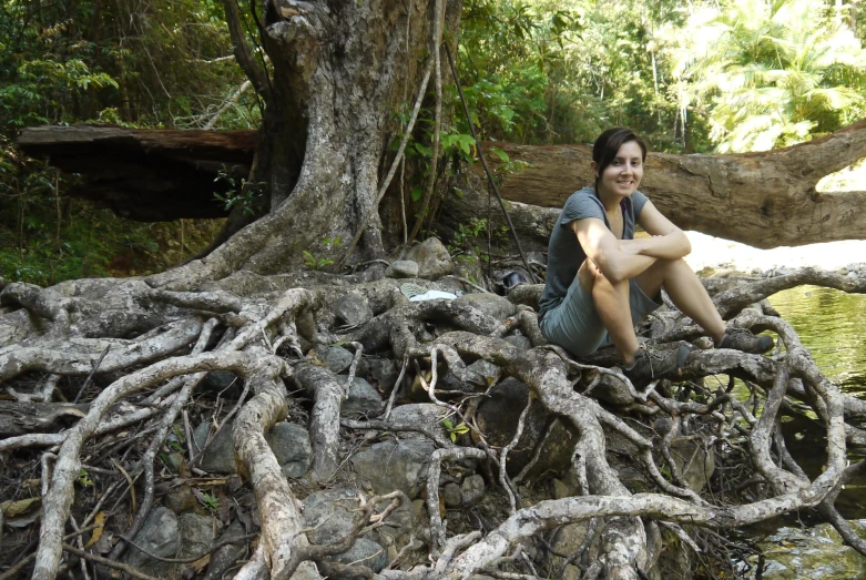 woman sitting on tree nches in water and surrounded by vegetation