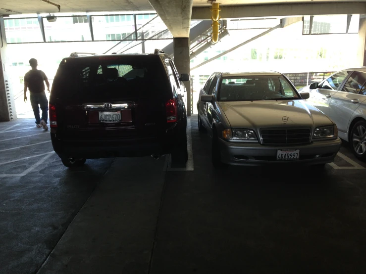 three cars are in the parking garage at a gas station