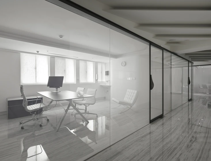 a glass wall in an office building is reflecting two computer screens