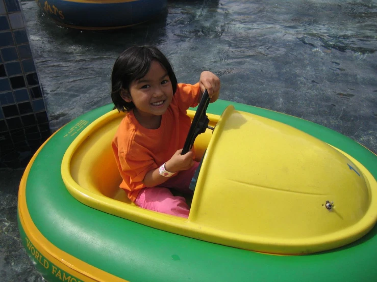 a little girl sitting in a small boat on the water