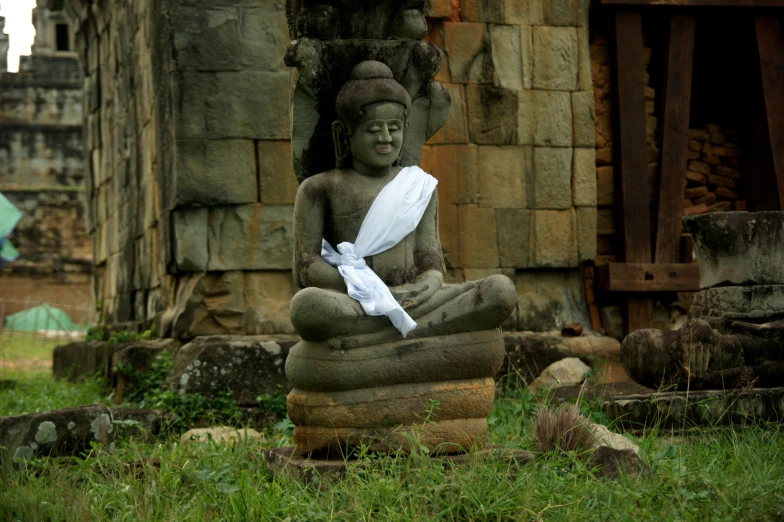 a statue of a buddha with folded paper on it