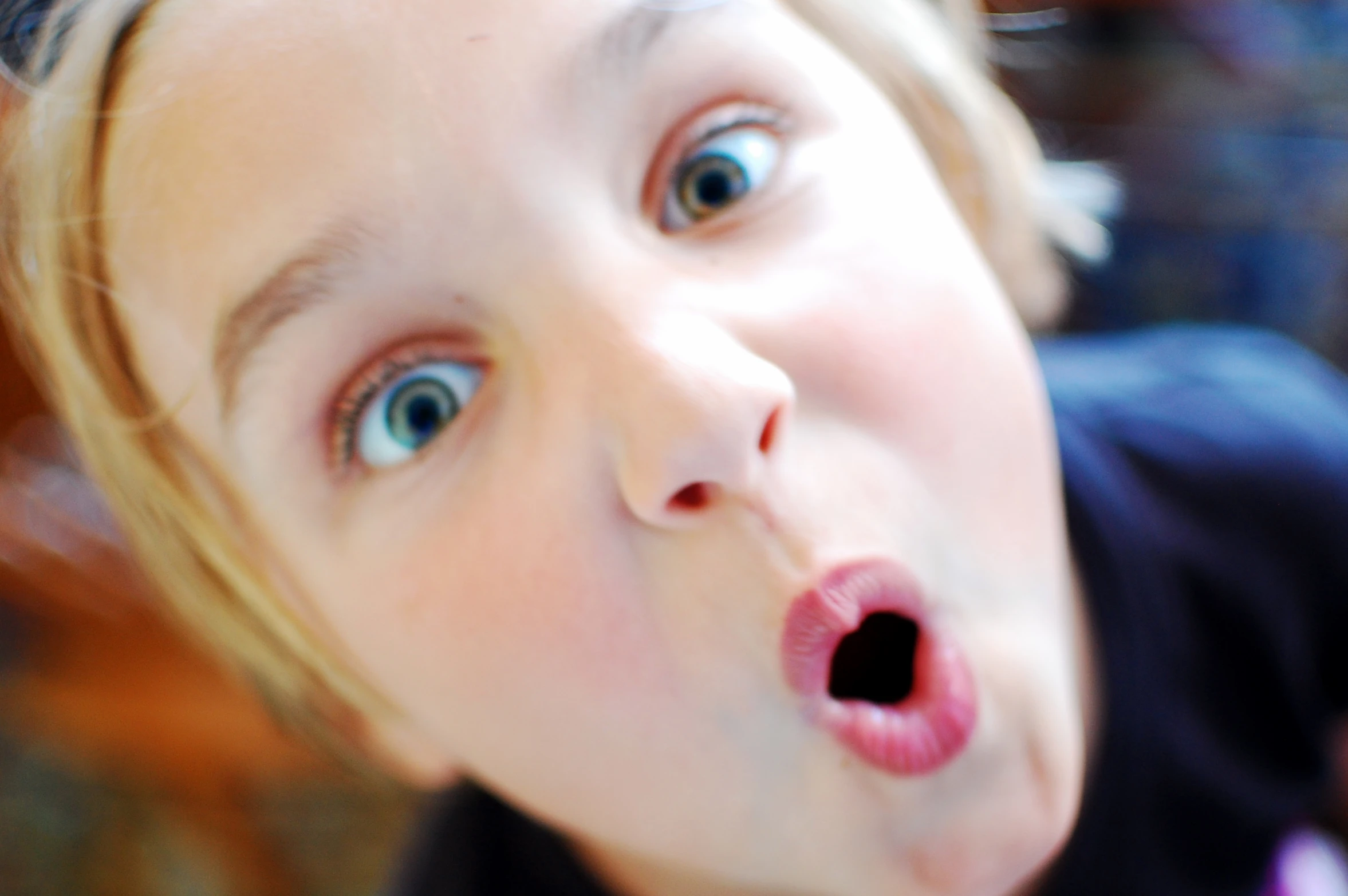 a young child with big blue eyes and long tongue