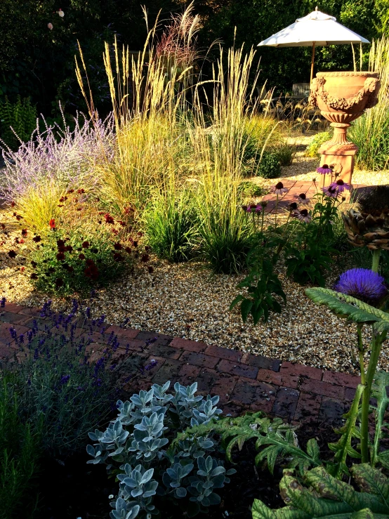 colorful garden area with a white umbrella and stone pathway