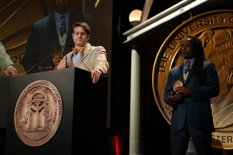 a man standing in front of a lectern talking at a podium