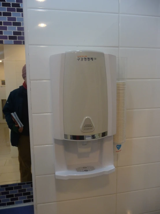 a beige wall mounted urinal with a white base