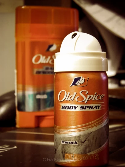 an orange old spice body spray bottle with its cap on