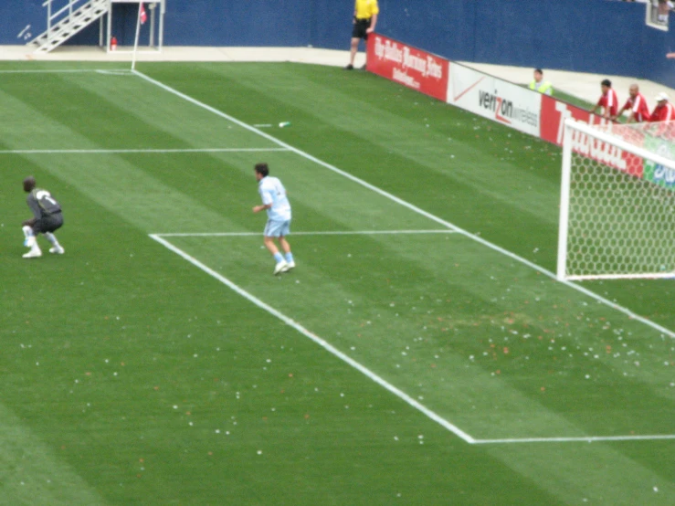 two men play soccer on the field as fans look on