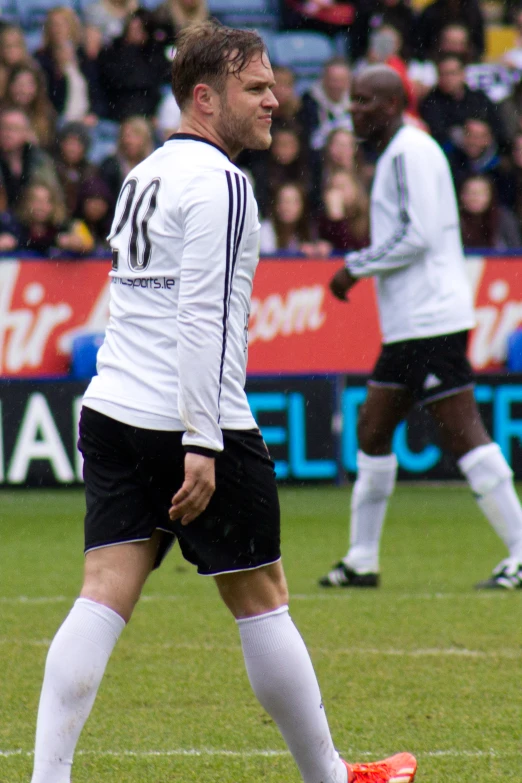 a man in white jersey and black shorts playing soccer