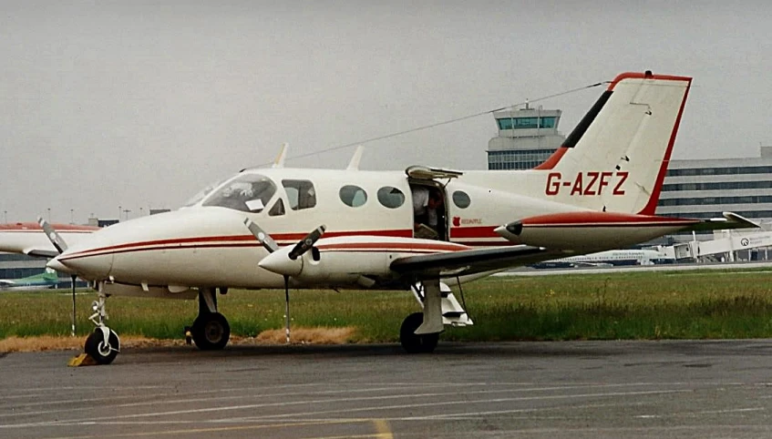 small airplane parked at the airport with another plane in the background