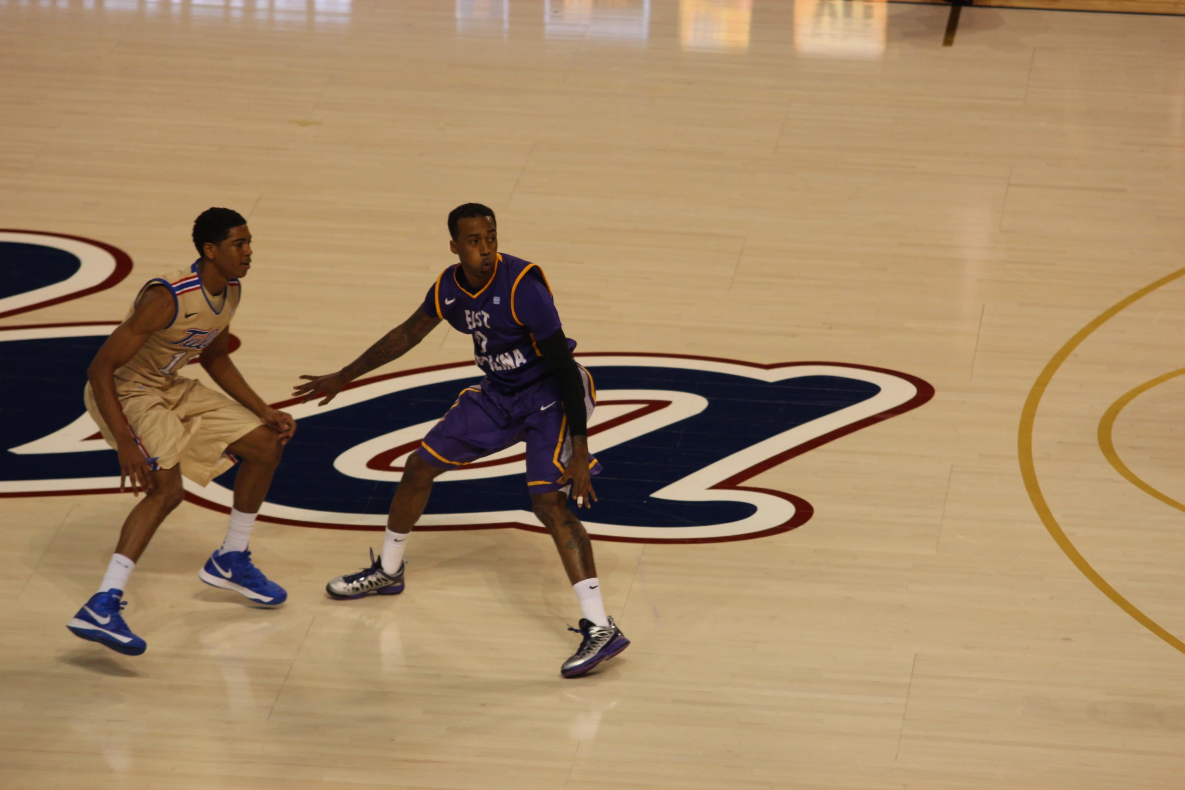 two men on opposing teams are playing basketball