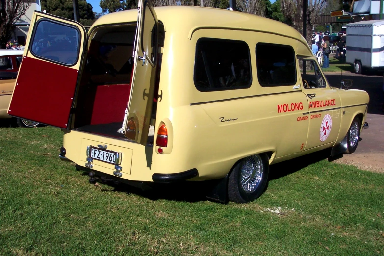 two old school style trucks parked on a grass field