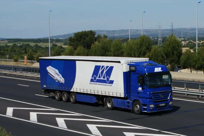 a large truck rides on a highway next to a road