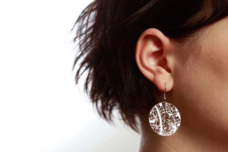 the profile of a woman wearing a earrings in the shape of a circle
