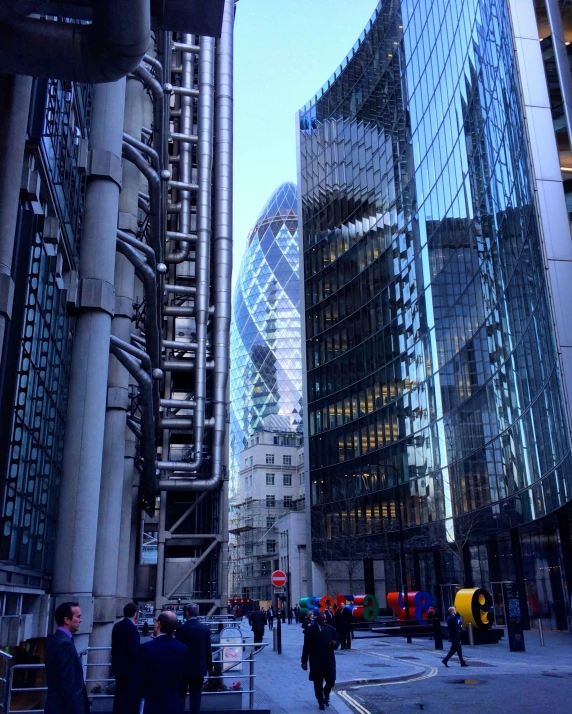 a group of people walking around outside a glass building