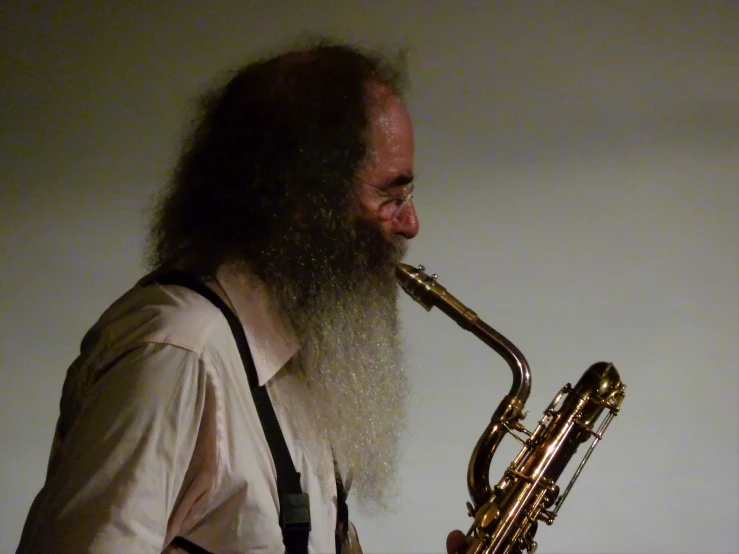 a man wearing glasses plays the saxophone on stage