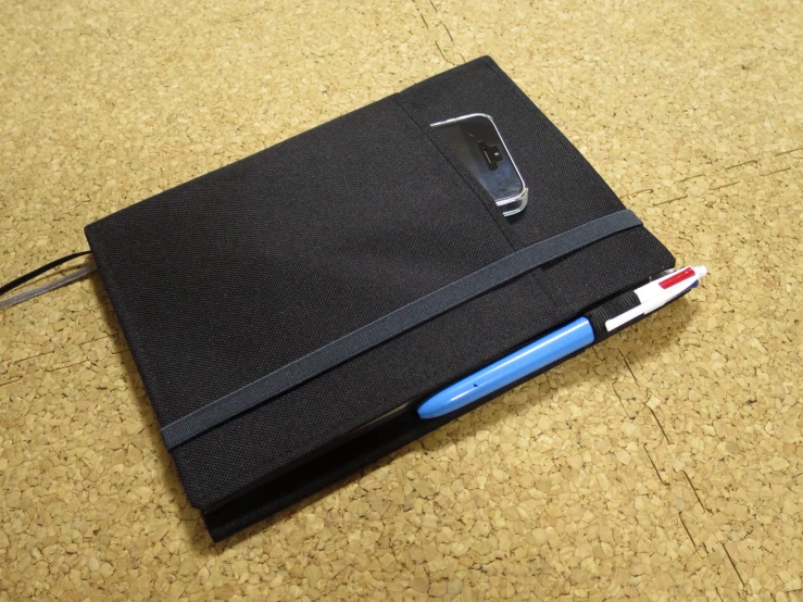 a notebook with a cell phone attached to it