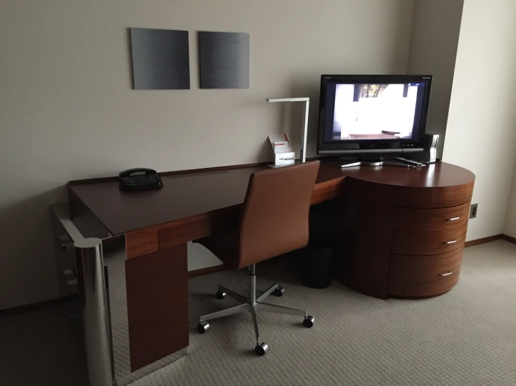 a small desk and chair in front of a tv