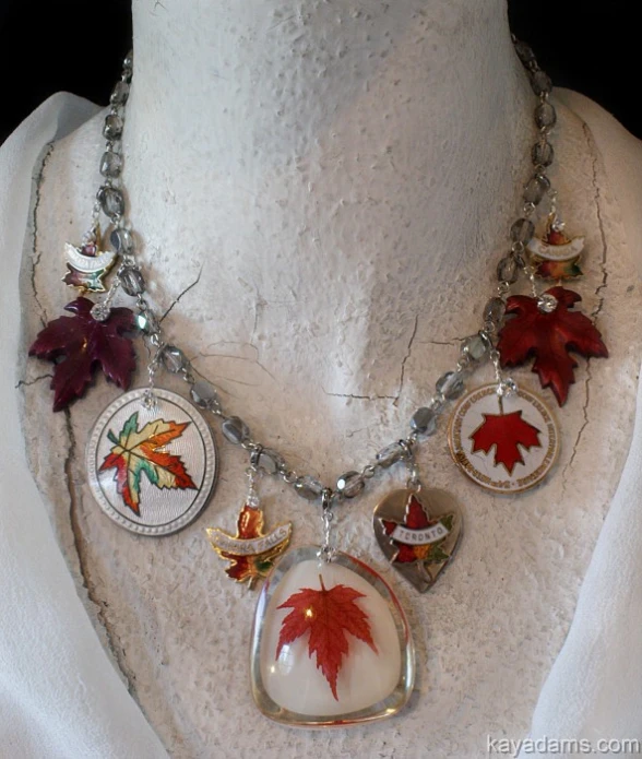 a white top and a red maple leaf necklace