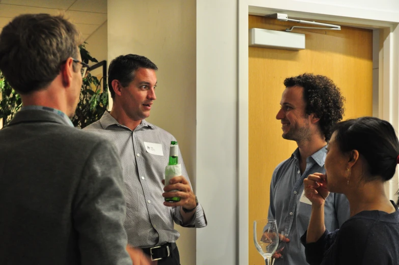 three men and a woman are standing around talking