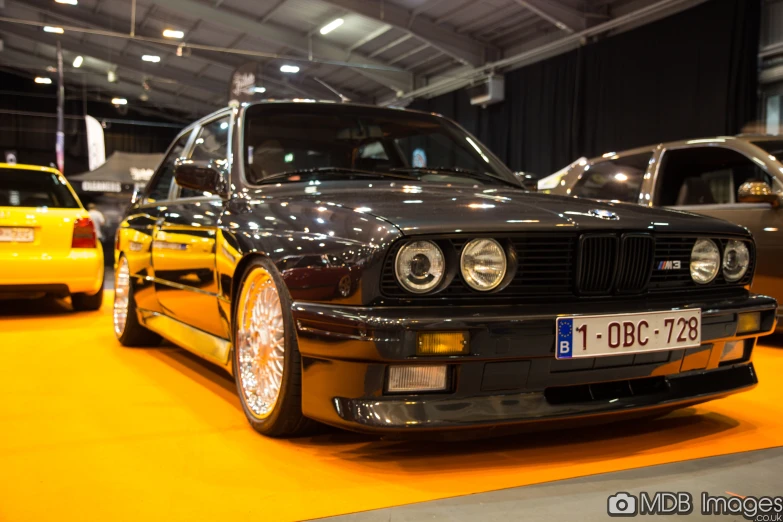 a bmw car in an auto show with others behind it