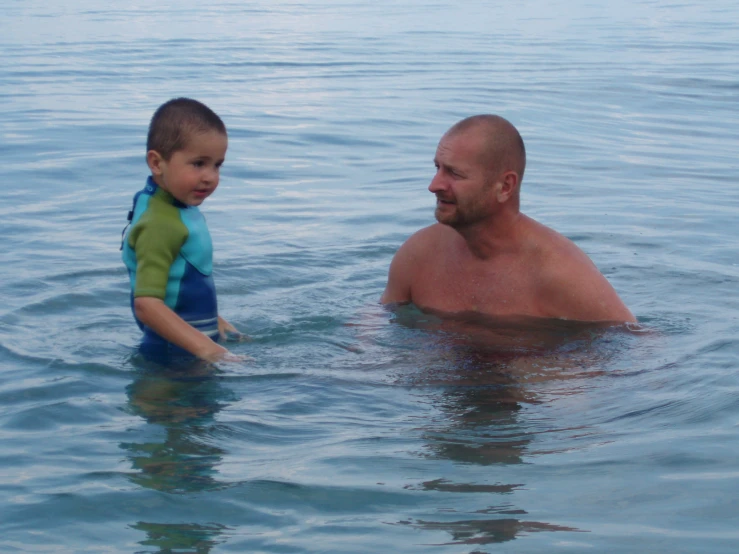 a man and his son standing in the ocean