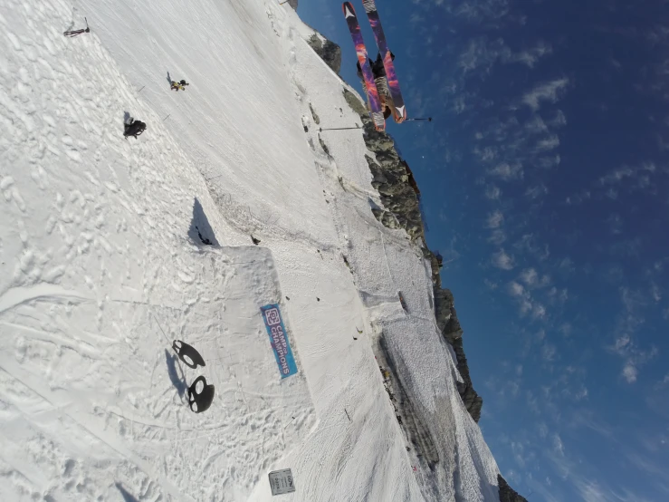 people are skiing down the snowy slope and some of them are doing tricks