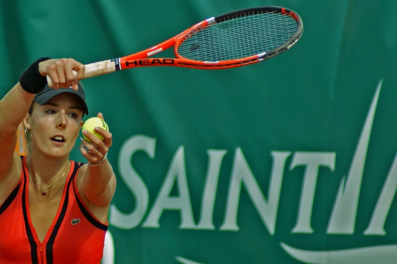 a woman with a tennis racket stands in the middle of swinging at a ball