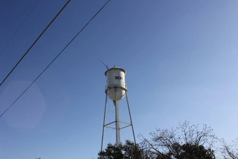 a white water tower sitting under a blue sky