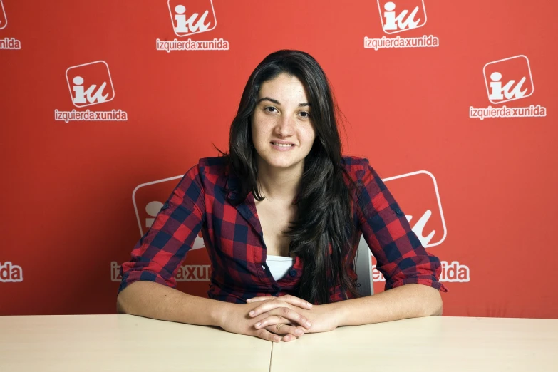 a woman wearing a blue and red shirt with a drink in her hand