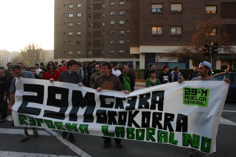 a group of men and women are carrying a sign while marching in a protest