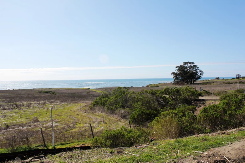 a view of a beach from the hill of a field