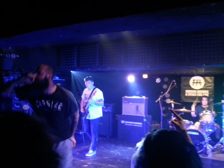 a band performing on a dark stage with bright lights