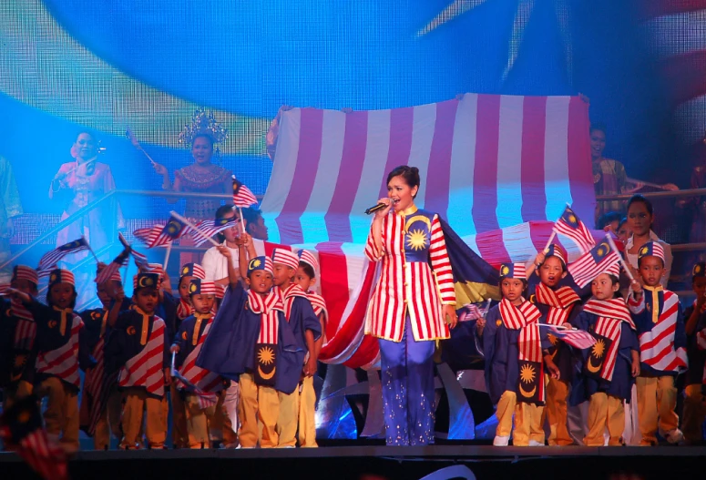 a person is on stage holding an umbrella and singing