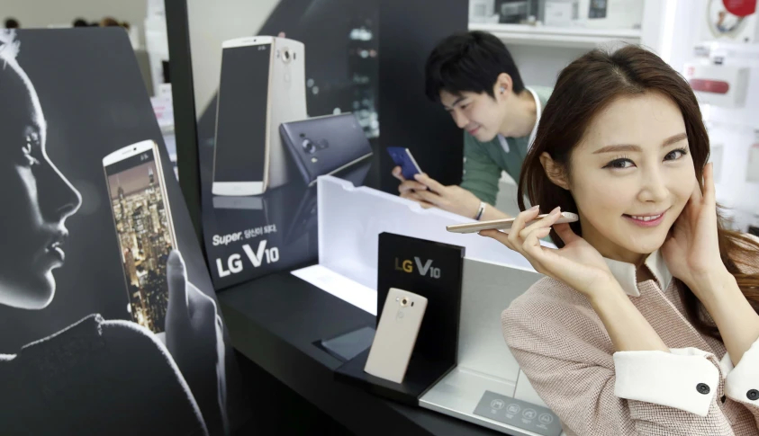 a young woman poses next to a display of electronic devices