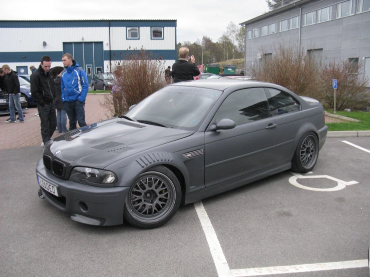 a car parked in a parking lot next to people