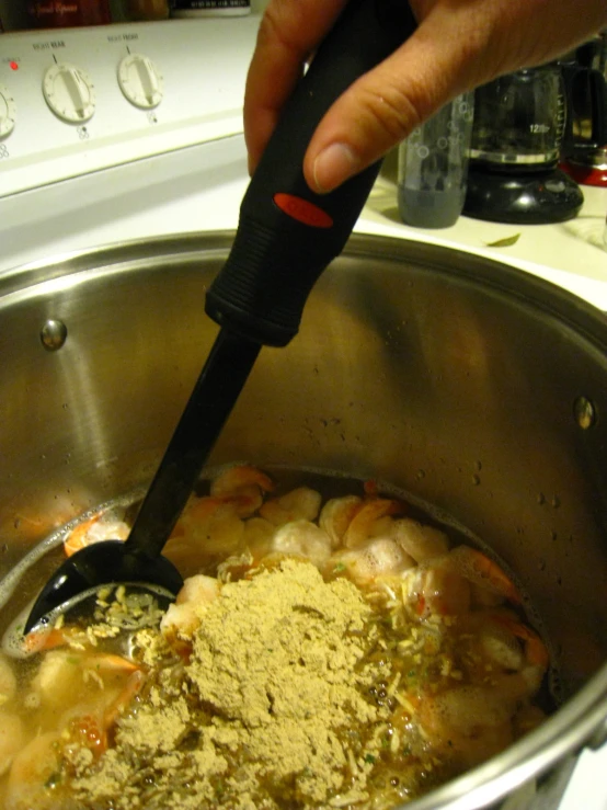 a person stirring a pot with some food