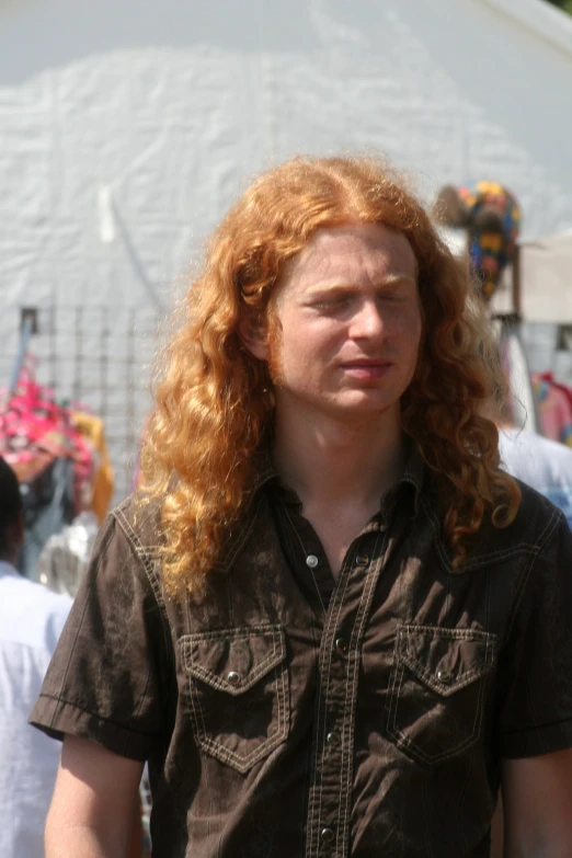 a long haired red headed man with a big smile