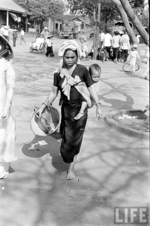 there are many women carrying their babies on a street