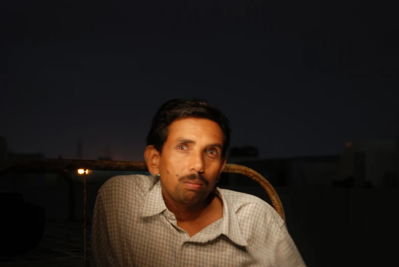 a man in a brown shirt staring into the distance
