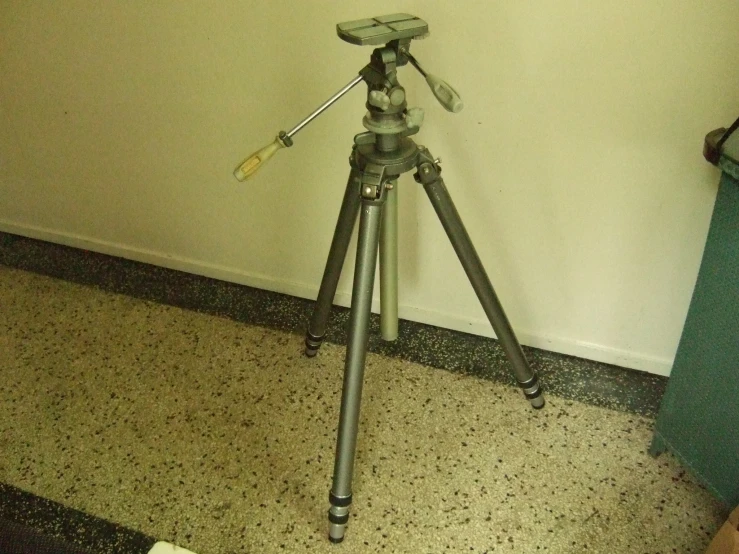 a camera tripod with an animal laying on the floor