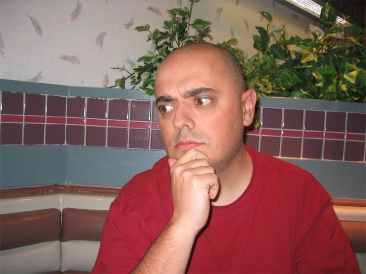 a man sitting in front of a plant on a kitchen table