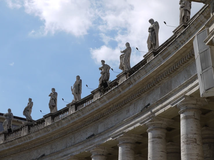 a group of statues are standing on top of a building