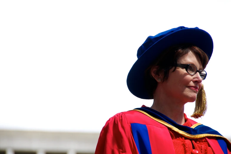 a woman is wearing a red robe and a blue hat