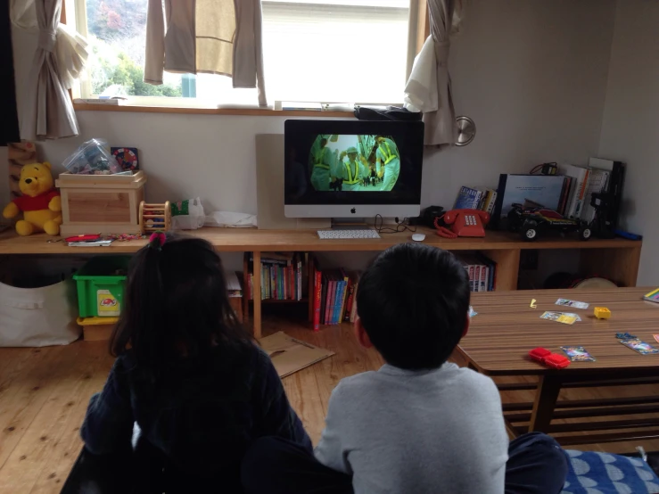 a  and girl watching television in their living room