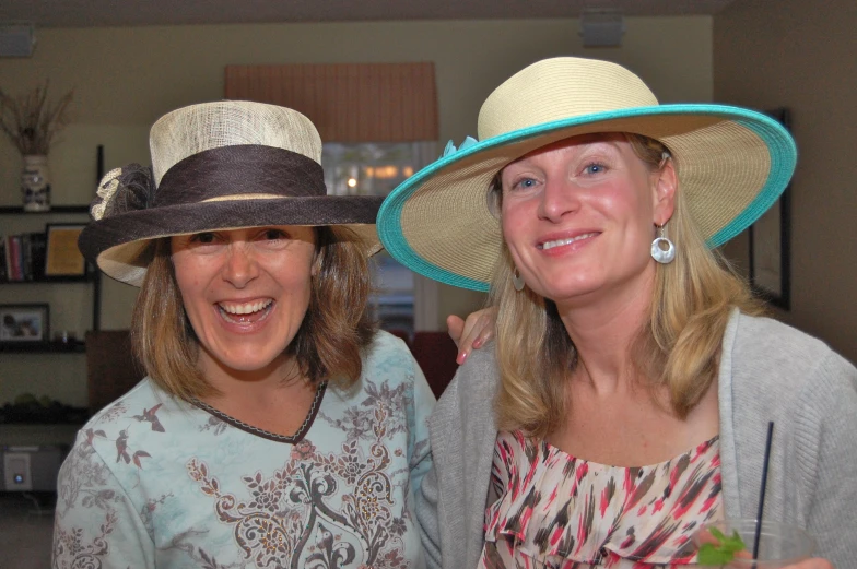 two women wearing hats pose for a picture