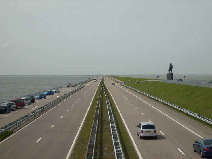 cars going down the road next to the ocean