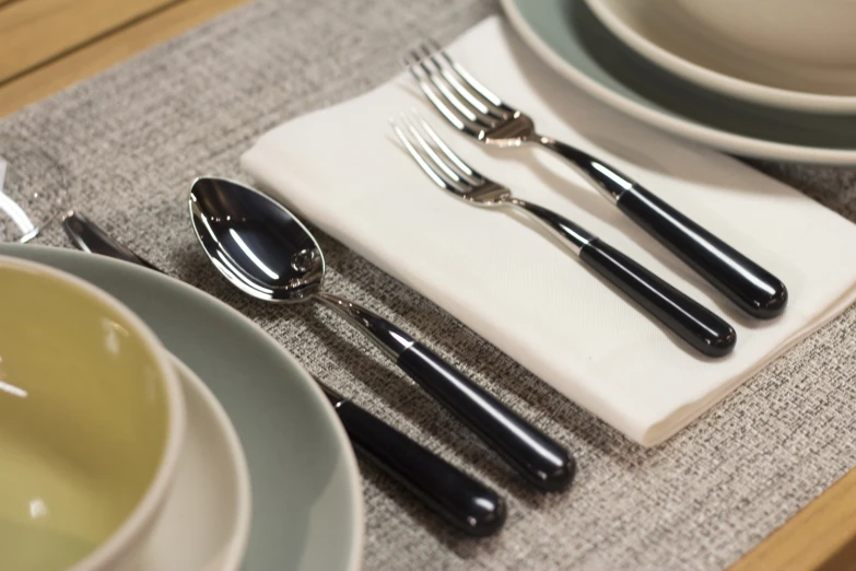 a table set with cutlery and cups for four