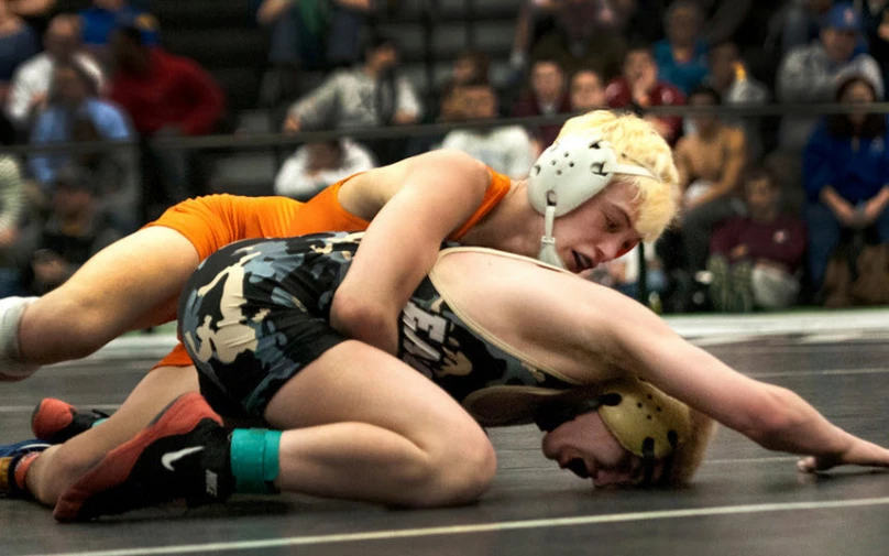 a couple of wrestlers wrestling in a wrestling match